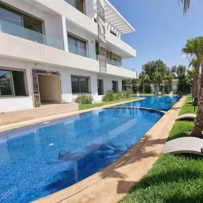 a large swimming pool in front of a building at Heaven Beach Front Apartment 2 Br in Sidi Rahal