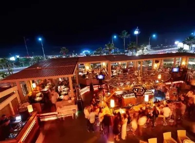 a crowd of people standing outside of a building at night at Heaven Beach Front Apartment 2 Br in Sidi Rahal