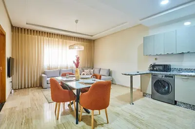 a kitchen and a living room with a table and chairs at City Escape Modern 1-Bed Near Casa Voyageurs in Casablanca
