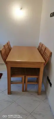 a wooden table with two chairs around it at Appartement Proche plage Bouznika Bouznika in Bouznika