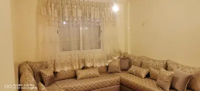 a large couch in a living room with a window at Appartement Proche plage Bouznika Bouznika in Bouznika