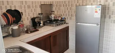 a kitchen with a refrigerator and a stove in it at Appartement Proche plage Bouznika Bouznika in Bouznika