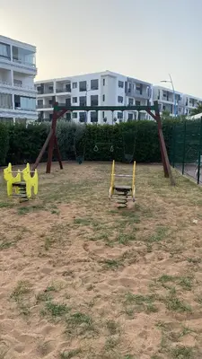 a playground with two yellow benches in a park at Résidence Balnéaire, Appartement 2 Chambres in Mansouria