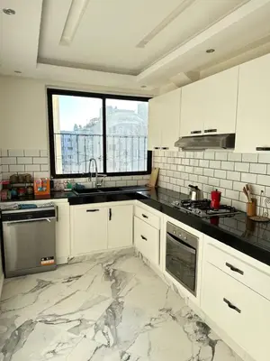 a kitchen with white cabinets and a marble floor at Chambre à Agdal Rabat dans un appartement partagé -king bed- in Rabat