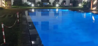 a large swimming pool with blue water at night at Aerostay Jamal in Dah Hammou Ben Cheïkh