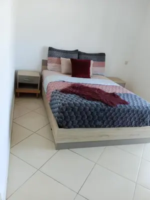 a bedroom with a bed with a wooden frame at Complex garden beach2 sidi rahal in Sidi Rahal