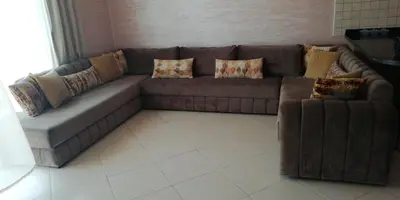 a brown couch in a living room with pillows at Complex garden beach2 sidi rahal in Sidi Rahal