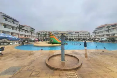 a large swimming pool with people in the water at Complex garden beach2 sidi rahal in Sidi Rahal