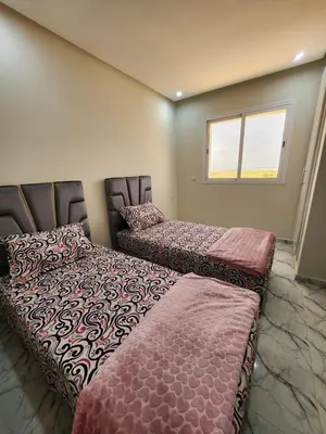 two beds sitting next to each other in a room at Résidence Rose Marie 24 lot 92A à côté de Harhoura in El Harhoura