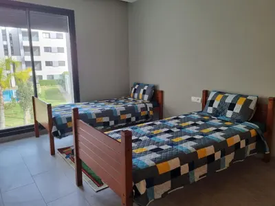 a bedroom with two beds and a window at Bel appartement à Harhoura in Oulad Kerroum