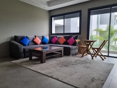 a living room with a couch and a table at Bel appartement à Harhoura in Oulad Kerroum