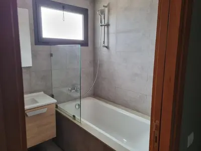 a bathroom with a shower and a tub and a sink at Bel appartement à Harhoura in Oulad Kerroum