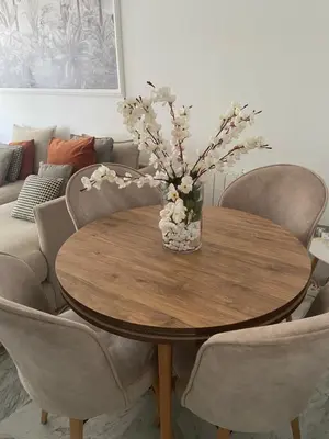 a wooden table with a vase of flowers on it at Charmant appartement 2 chambres à Casablanca, à 10 min de la plage in Casablanca