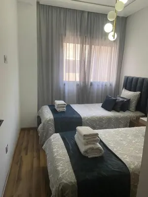 a bedroom with three beds with towels on them at Charmant appartement 2 chambres à Casablanca, à 10 min de la plage in Casablanca