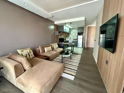 a living room with a couch and a table and a television at Modern City Centre Apartment in Casablanca