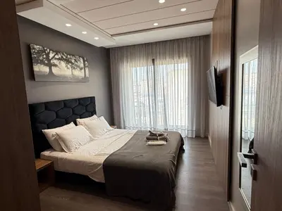 a bedroom with a bed and a large window at Modern City Centre Apartment in Casablanca