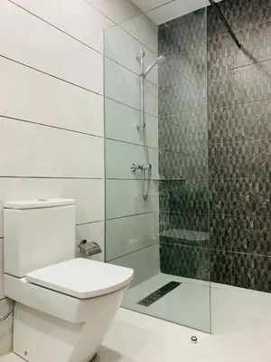 a bathroom with a toilet and a glass shower at Modern City Centre Apartment in Casablanca