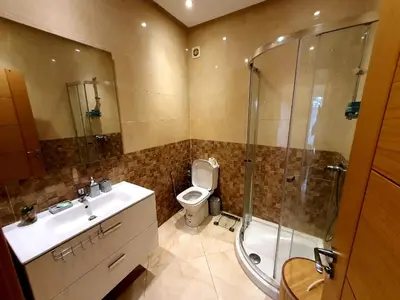 a bathroom with a toilet and a shower and a sink at Appartement résidence kettani jardin privatif accès direct piscine et aire de jeu in Bouznika