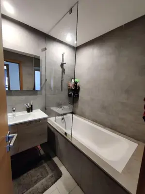 a bathroom with a bath tub and a sink at Blue Themed Vacation Condo in Temara