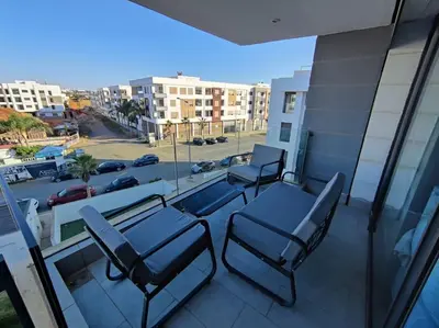 a balcony with chairs and a view of a street at Blue Themed Vacation Condo in Temara