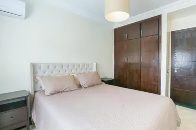 a bedroom with a large bed and a wooden cabinet at At Casablanca 's Home in Casablanca