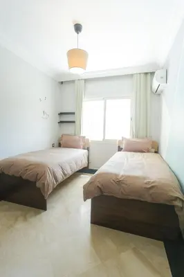 two beds in a room with a window at At Casablanca 's Home in Casablanca
