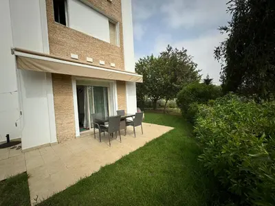 a patio with a table and chairs in a yard at Golf City Prestigia Bouskoura in Bouskoura