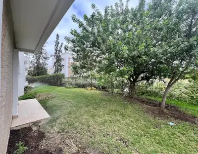 a yard with a tree and a house at Golf City Prestigia Bouskoura in Bouskoura