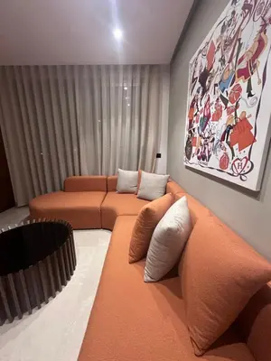 a living room with two orange couches and a painting at CFC Luxury View Appt Anfa park in Casablanca