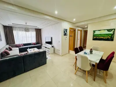 a living room with a couch and a table at Douce escale vue sur piscine - Costa Beach bouznika in Bouznika