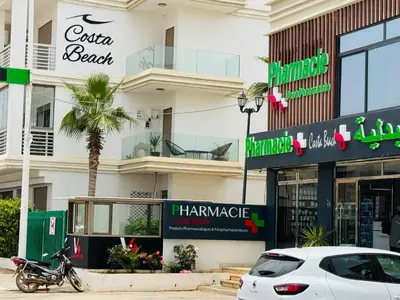 a white car parked in front of a building at Douce escale vue sur piscine - Costa Beach bouznika in Bouznika