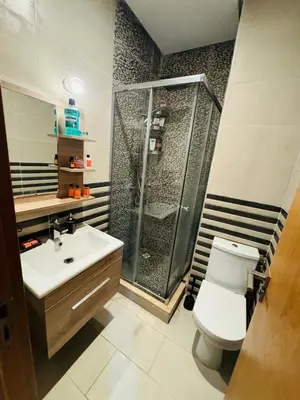 a bathroom with a shower and a toilet and a sink at Douce escale vue sur piscine - Costa Beach bouznika in Bouznika
