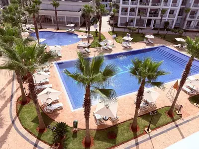 an overhead view of a pool with palm trees and chairs at Douce escale vue sur piscine - Costa Beach bouznika in Bouznika