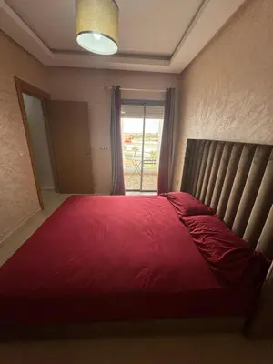 a bedroom with a large red bed with a window at Douce escale vue sur piscine - Costa Beach bouznika in Bouznika