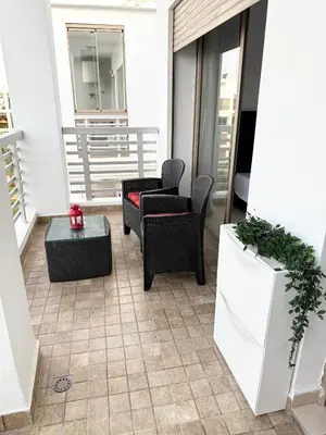 a balcony with two chairs and a table at Douce escale vue sur piscine - Costa Beach bouznika in Bouznika