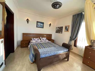 a bedroom with a bed with a blue comforter at Villa Taroub avec piscine et vue sur mer in Temara