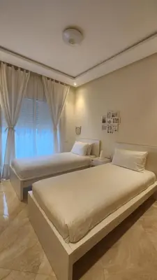 a bedroom with two beds and a window at Beach condo at Casabay plage Sidi Rahal in Casablanca