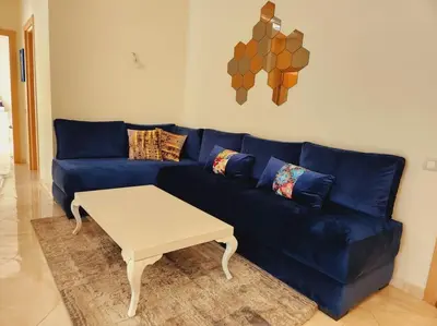a blue couch with a coffee table in a living room at Beach condo at Casabay plage Sidi Rahal in Casablanca