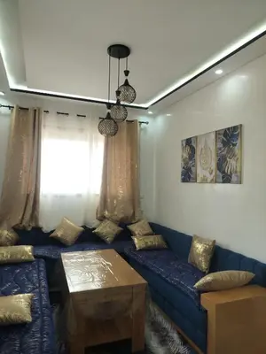 a living room with a blue couch and a table at Dahomey city in Bouznika