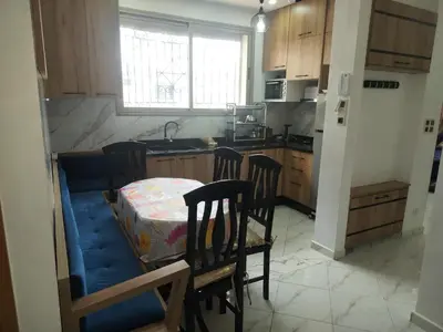 a kitchen with a table and chairs in a kitchen at Dahomey city in Bouznika