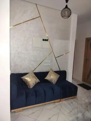 a blue couch with two pillows in a room at Dahomey city in Bouznika