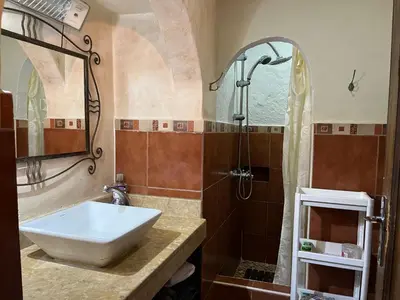 a bathroom with a sink and a shower at Lovely flat in nice garden in Rabat