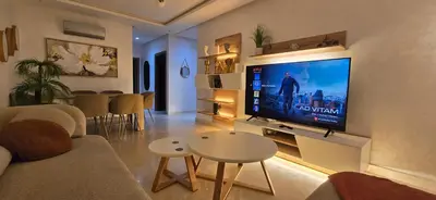 a living room with a large flat screen tv on a wall at Appartement charmant au parc de Mohammedia, à seulement 2 pas de la plage in Mohammedia