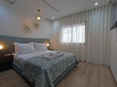 a bedroom with a large bed and a window at Appartement charmant au parc de Mohammedia, à seulement 2 pas de la plage in Mohammedia
