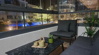 a chair and a table in front of a building at Appartement balnéaire magnifique à Mohammedia Mansouria in Mansouria