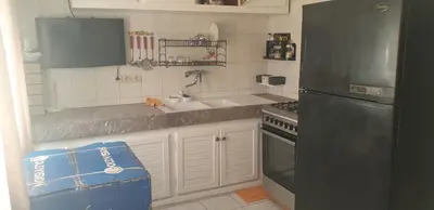a kitchen with a black refrigerator and a sink at إقامة الياسمين in Rabat