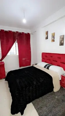 a bedroom with a large bed with a red headboard at Zen and cosy Appart Rose Marie Kasbah in Skhirat