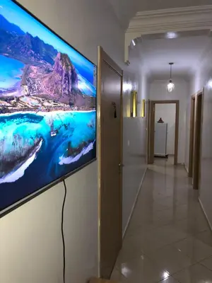 a large flat screen tv on a wall in a hallway at Zen and cosy Appart Rose Marie Kasbah in Skhirat