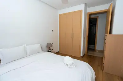 a bedroom with a white bed and a closet at Appartement avec piscine in Rabat