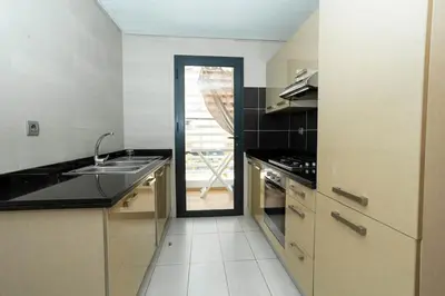 a kitchen with a sink and a door to a patio at Appartement avec piscine in Rabat